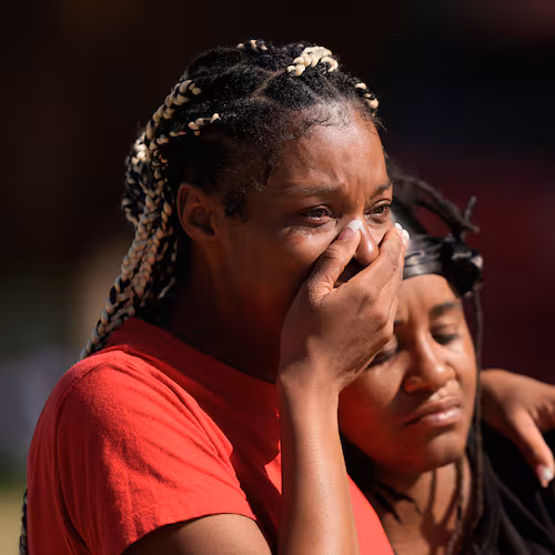 People grieve as they comfort each other outside the scene of a mass shooting, Sunday, April 19, 2026, in Shreveport, La. (AP Photo/Gerald Herbert)