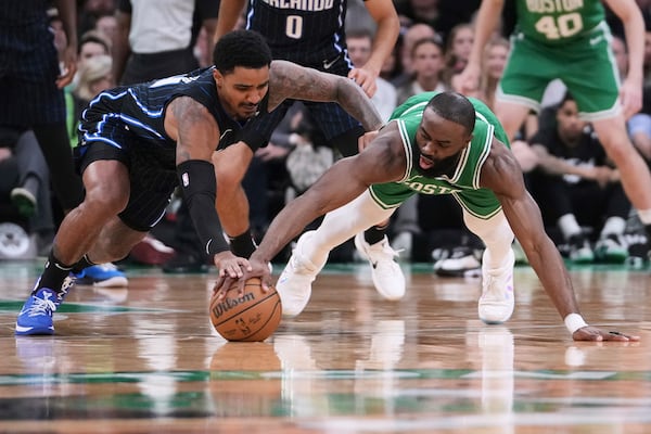 Boston Celtics guard Jaylen Brown, right, battles for a loose ball against Orlando Magic guard Gary Harris, left, during the first half in game 2 of a first-round NBA playoff basketball series, Wednesday, April 23, 2025, in Boston. (AP Photo/Charles Krupa)