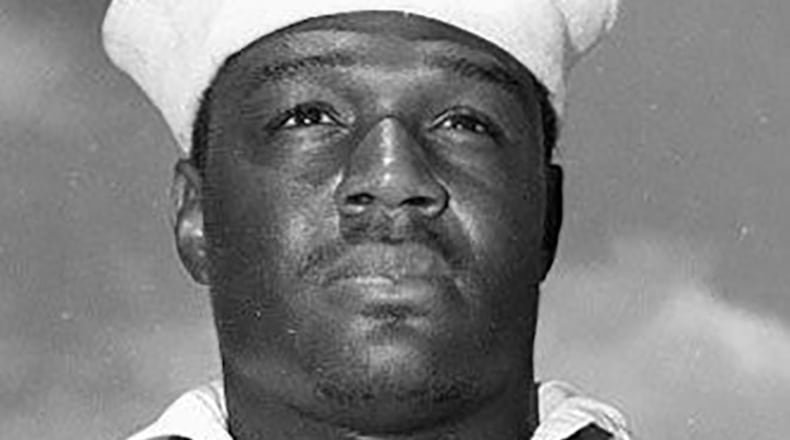 Doris "Dorie" Miller, USN Mess Attendant Second Class, May 27, 1942 after presentation of the Navy Cross by Admiral Chester W. Nimitz aboard USS Enterprise.