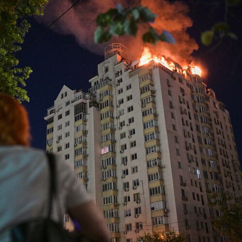 A woman looks at an apartment building burning after a Russian missile attack in Kyiv, Ukraine, Thursday, July 2, 2026. (AP Photo/Danylo Antoniuk)