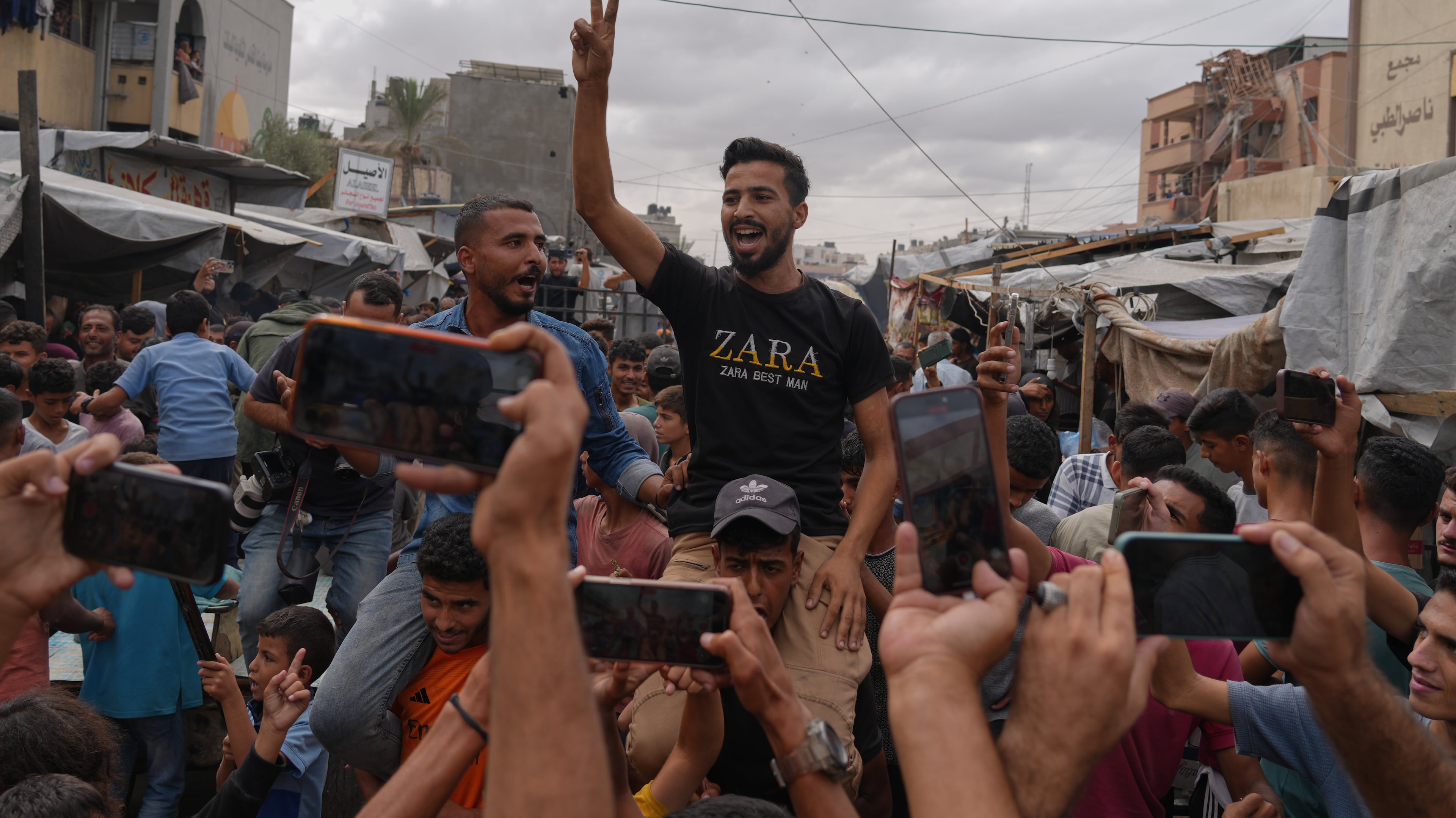 Palestinians celebrate following the announcement that Israel and Hamas have agreed to the first phase of a peace plan to pause the fighting, in Khan Younis, southern Gaza Strip, Thursday, Oct. 9, 2025. (AP Photo/Jehad Alshrafi)