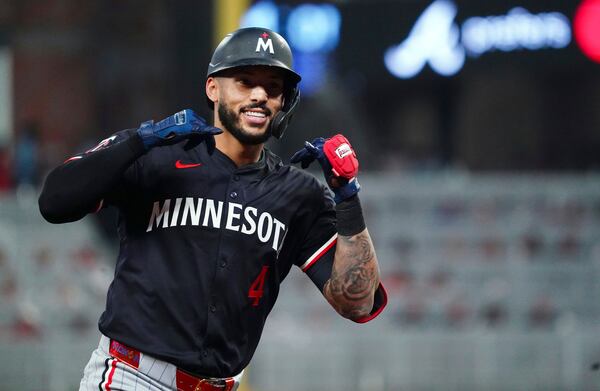 Minnesota Twins shortstop Carlos Correa (4) celebrates to the dugout as he rounds third base on his solo homerun against the Atlanta Braves during the fourth inning in a baseball game at Truist Park, Saturday, April 19, 2025, in Atlanta. (AP Photo/ John David Mercer)