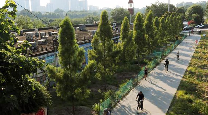 Panoramic for gatefold presentation in BeltLine Book. This shows the Eastside Trail at dusk, with Old Fourth Ward Park lit up in green at left.