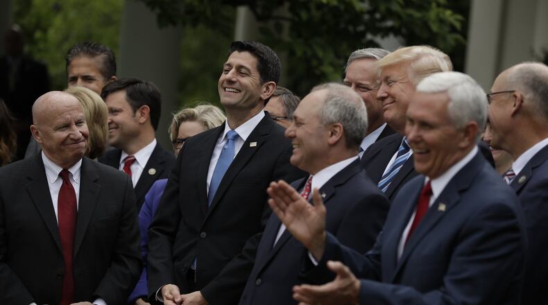 U.S. House Speaker Paul Ryan of Wisconsin — flanked by House Ways and Means Committee Chairman Kevin Brady, R-Texas, and House Majority Whip Steve Scalise of Louisiana — smiles as President Donald Trump speaks in the Rose Garden of the White House in Washington on May 4 after the House pushed through a health care bill. (AP Photo/Evan Vucci)