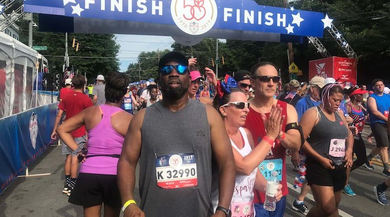 Willie Hatchett (in gray shirt) near the finish line of the 50th running of The Atlanta Journal-Constitution Peachtree Road Race on July 4, 2019. Three years later, Hatchett went into cardiac arrest about a mile into the running of the race. He received quick help from a police officer and three physicians. He survived and has plans to run in the 2023 AJC Peachtree Road Race. (Photo contributed by Willie Hatchett)