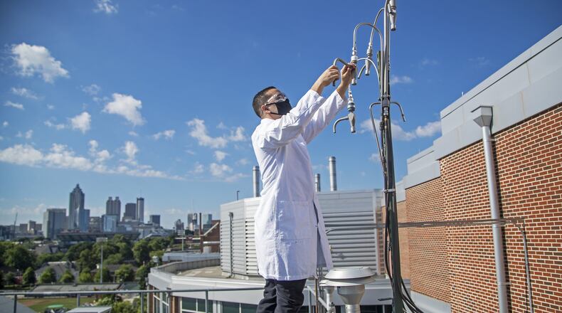 06/12/2020 - Atlanta , Georgia - Jean Carlos Rivera-Rios, who has a doctorate in Chemistry, cleans an inlet for debris while working with a machine that collects air located on the roof of the Ford Environmental Science & Technology Building on the main campus of the Georgia Institute of Technology in Atlanta, Friday, June 12, 2020. Rivera-Rios is working to measure the air quality in Atlanta. (ALYSSA POINTER / ALYSSA.POINTER@AJC.COM)