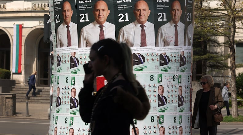 People pass posters of former president Rumen Radev, after Bulgaria's parliamentary election, in Sofia, Monday, April 20, 2026. (AP Photo/Valentina Petrova)