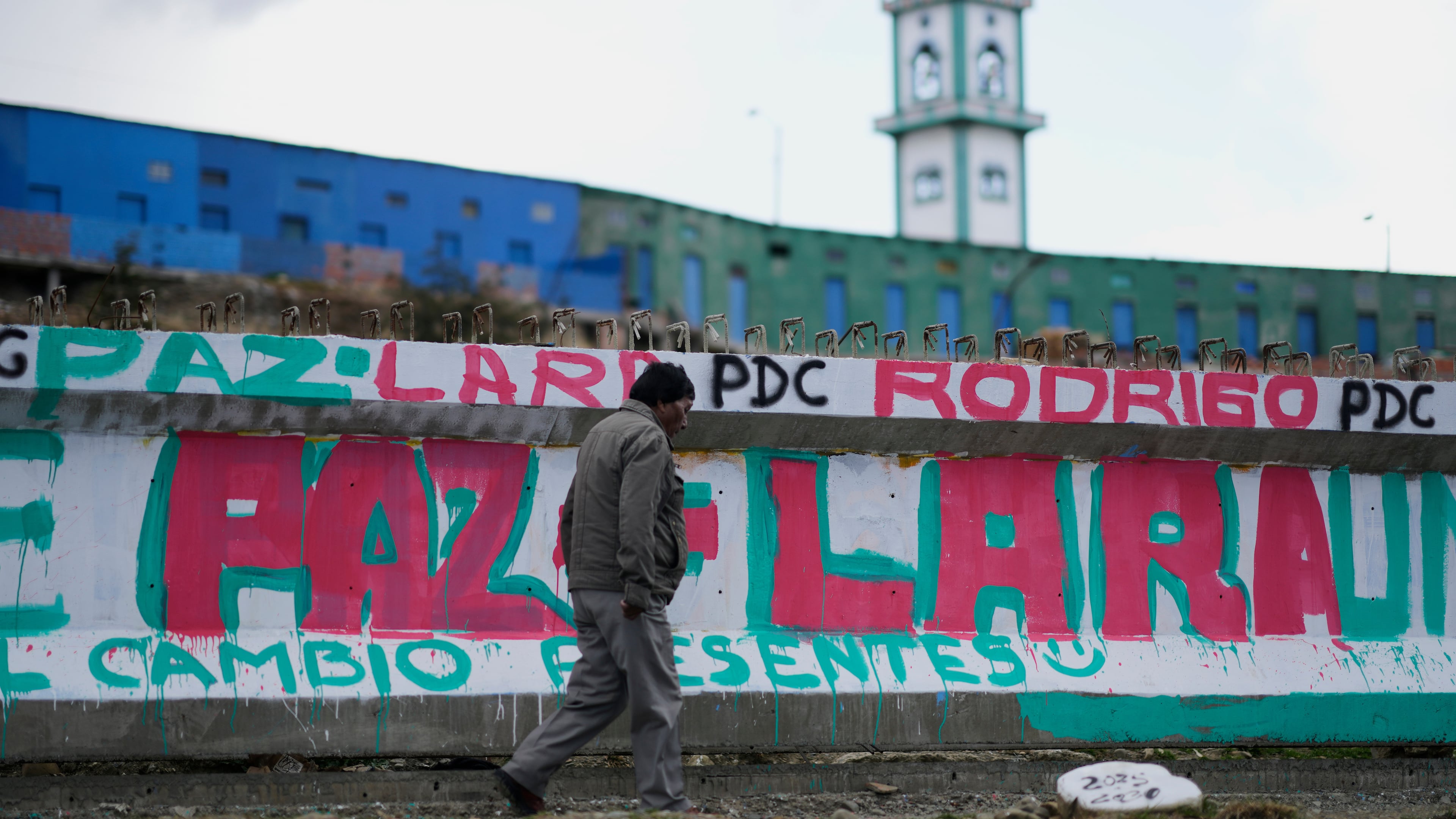 A man walks past a mural promoting presidential candidate Rodrigo Paz days ahead of the runoff election, in El Alto, Bolivia, Thursday, Oct. 16, 2025. (AP Photo/Natacha Pisarenko)