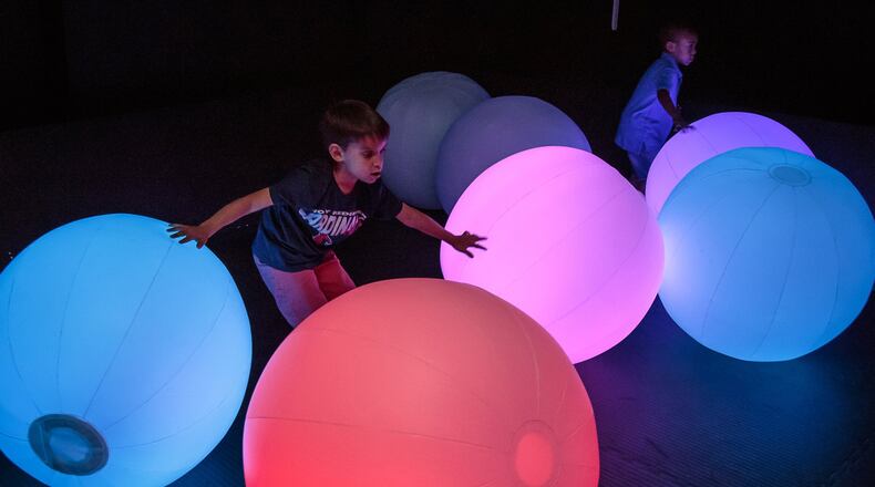 Harrison Urrea plays with the Light Ball Orchestra installation at the recent grand opening for teamLab, a digital art experience at the Mall of Georgia. STEVE SCHAEFER / SPECIAL TO THE AJC