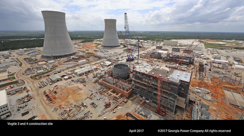 The cooling towers for Plant Vogtle reactors 3 and 4 rise above the construction sites.