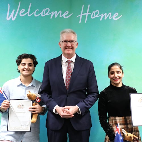 Fatemeh Pasandideh, left, and Atefeh Ramezanisadeh, former members of the Iranian women’s soccer team, stand with Australia's Minister for Home Affairs, Tony Burke, after receiving their citizenship in Brisbane, Australia, Wednesday, Aug. 5, 2026. (Department of Home Affairs via AP)