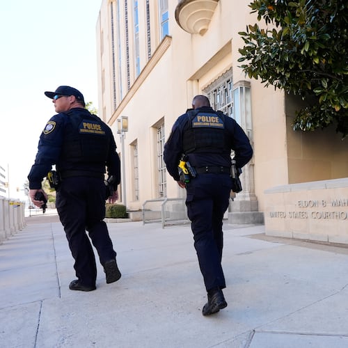 FILE - Officers with the Department of Homeland Security walk on the sidewalk outside the Eldon B. Mahon U.S. Courthouse during a trial for people connected to a 2025 shooting outside an ICE detention facility, in Fort Worth, Texas, March 12, 2026. (AP Photo/Tony Gutierrez, File)