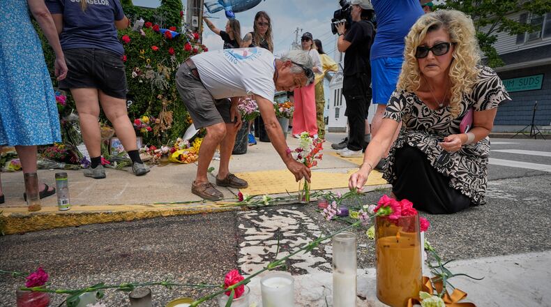 Mourners place flowers and candles in Biddeford, Maine, Wednesday, July 15 2026, near the blood-stained pavement where Johan Sebastián Durán Guerrero was pulled from his car on Monday by U.S. Immigration and Customs Enforcement agents. (AP Photo/Robert F. Bukaty)