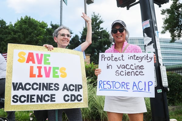Sue Binder, 69, and Denise Coo, 62, hold signs in protest outside the CDC in Atlanta on Wednesday, June 25, 2025. Binder and Koo are both former CDC employees. “We love the agency and are heartbroken to see what’s happened to it,” Binder said. (Abbey Cutrer/AJC)