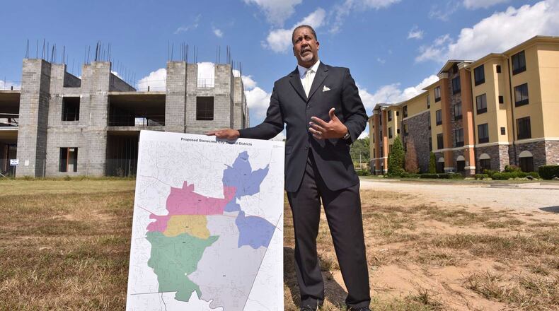 Jason Lary, the president for Stonecrest Yes, holds a map of the proposed city of Stonecrest as he talks about why he believes the area should incorporate in front of an unfinished hotel near Stonecrest Mall. Voters will decide whether to create the city of Stonecrest in a Nov. 8 referendum. HYOSUB SHIN / HSHIN@AJC.COM