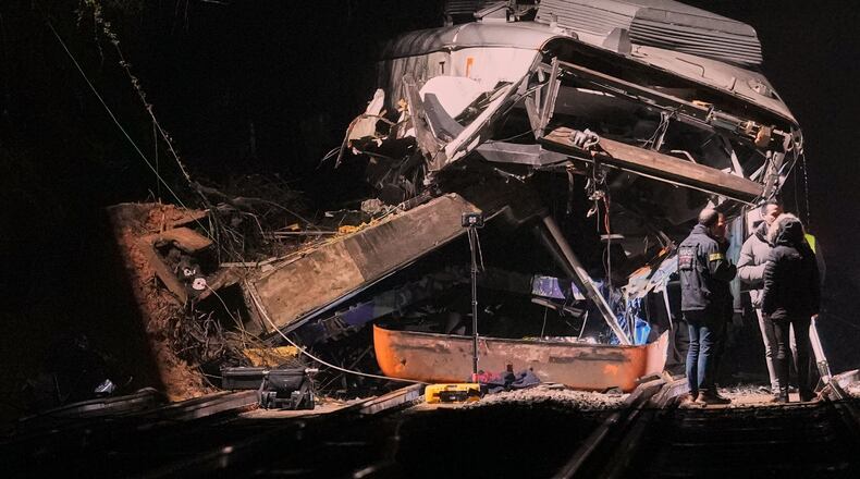 Emergency crews respond after a commuter train derailed when a retaining wall collapsed onto the tracks in Gelida, near Barcelona, Spain, Tuesday, Jan. 20, 2026. (AP Photo/Joan Mateu Parra)