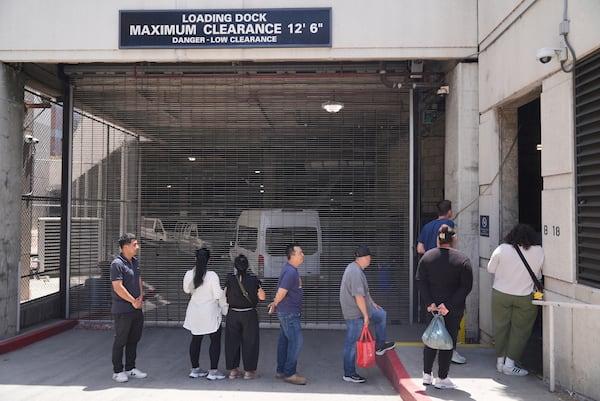 Alejandro Barranco, left, waits in line at the Metropolitan Detention Center to check on his father Narciso, who was recently detained by federal agents, on Monday, June 23, 2025, in Los Angeles. (AP Photo/Damian Dovarganes)