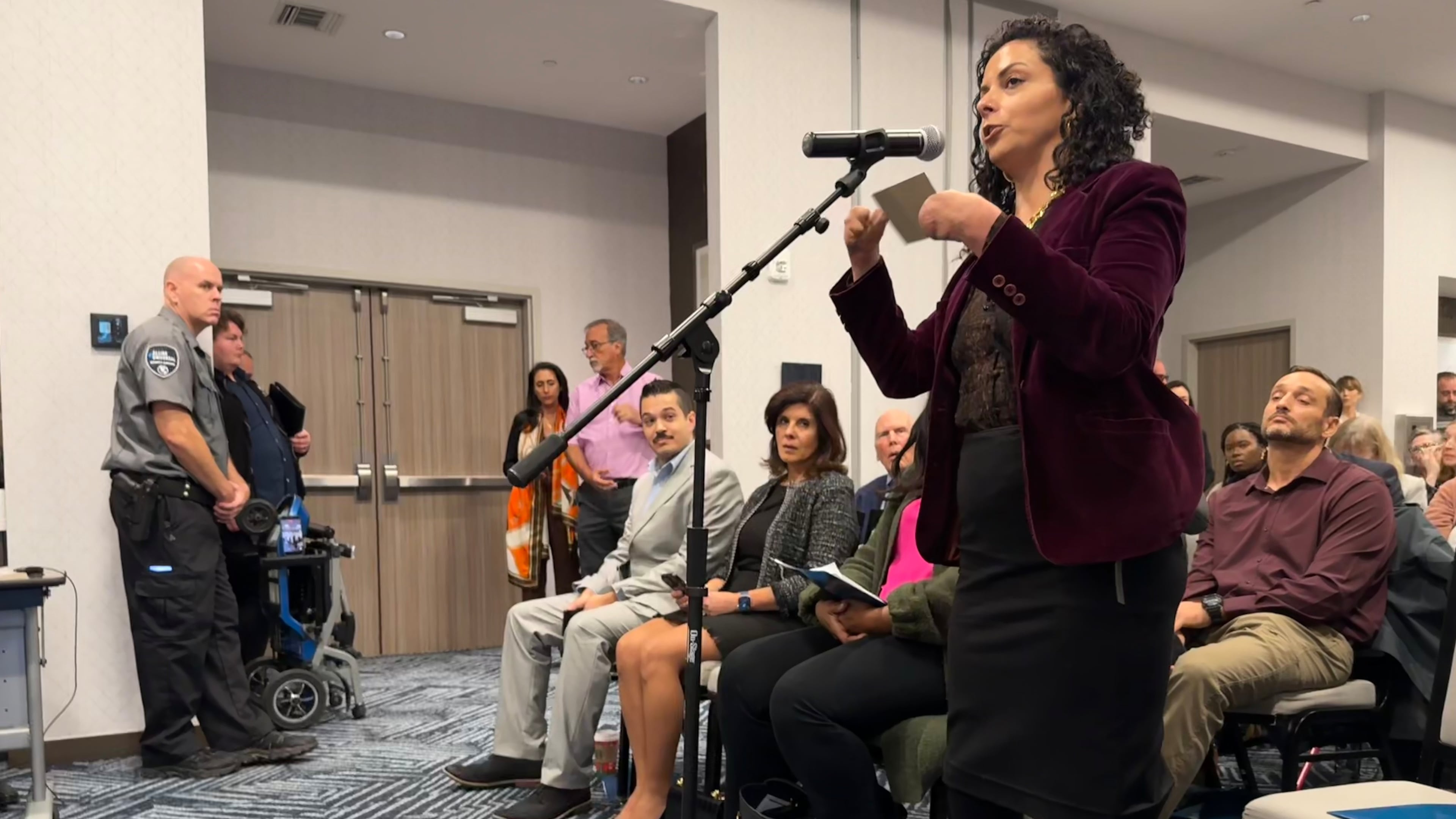 Jamie Schanbaum, whose legs and fingers were amputated after she contracted meningitis as a college student, testifies in support of vaccine mandates at a public hearing held by the Florida Department of Health on Friday, Dec. 12, 2025 in Panama City Beach, Fla. (AP Photo/Kate Payne)