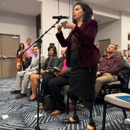 Jamie Schanbaum, whose legs and fingers were amputated after she contracted meningitis as a college student, testifies in support of vaccine mandates at a public hearing held by the Florida Department of Health on Friday, Dec. 12, 2025 in Panama City Beach, Fla. (AP Photo/Kate Payne)