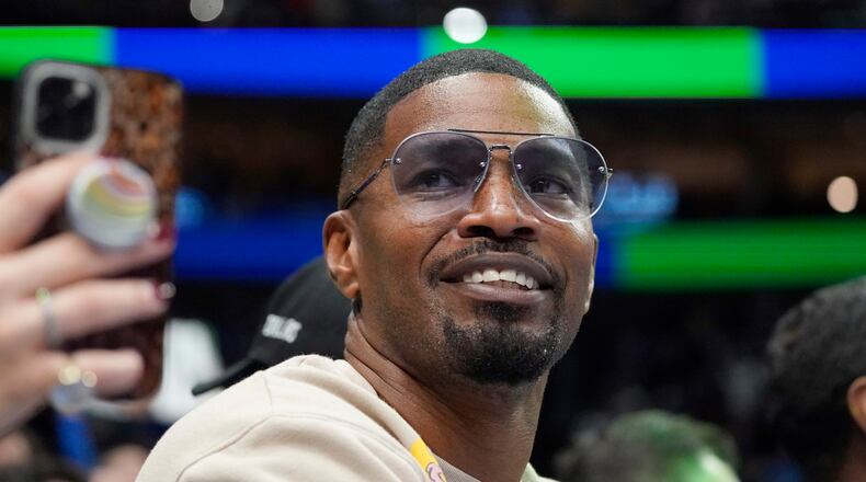 Jamie Foxx smiles during an NBA basketball game between the Washington Wizards and Dallas Mavericks in Dallas, Saturday, Nov. 27, 2021. Academy Award winning actor, Grammy winning singer and comedian says he “went to hell and back” but is recovering from an undisclosed medical condition. Foxx made his first public comments in an Instagram message posted on Friday, July 21, 2023 after being hospitalized in April.   (AP Photo/LM Otero, File)
