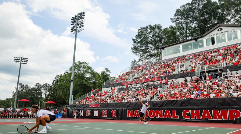 Georgia's Teodor Giusca serves as doubles teammate Phillip Henning crouches near the net as the No. 6 Bulldogs took on No. 11 Harvard in a NCAA Tennis Super Regional matchup Saturday at Henry Feild Stadium inside the Dan Magill Tennis Complex. (Tony Walsh/UGA Athletics)