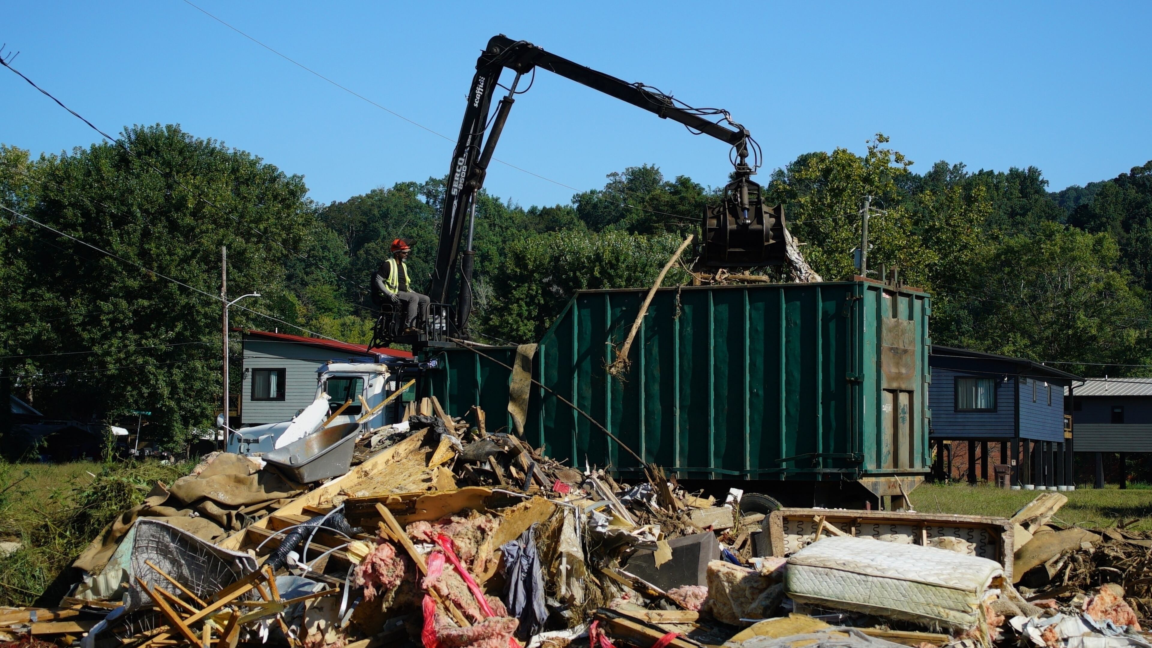 FILE -A claw operator scoops up debris from homes demolished following Hurricane Helene in Old Fort, N.C., on Thursday, Sept. 11, 2025. (AP Photo/Allen G. Breed, File)