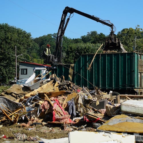 FILE -A claw operator scoops up debris from homes demolished following Hurricane Helene in Old Fort, N.C., on Thursday, Sept. 11, 2025. (AP Photo/Allen G. Breed, File)