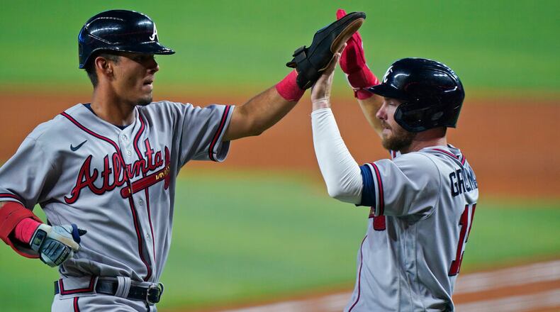 The Braves' Vaughn Grissom (left) and Robbie Grossman congratulate each other after they scored on a double by Chadwick Tromp on Saturday against the host Marlins. Grissom has started fast after making his MLB debut. (AP Photo/Wilfredo Lee)
