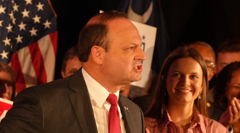 As his daughter, Anna Grace, looks on, South Carolina Attorney General Alan Wilson, left, speaks to supporters as he celebrates his GOP gubernatorial runoff victory in a hotel ballroom on Tuesday, June 23, 2026, in Columbia, S.C. (AP Photo/Meg Kinnard)