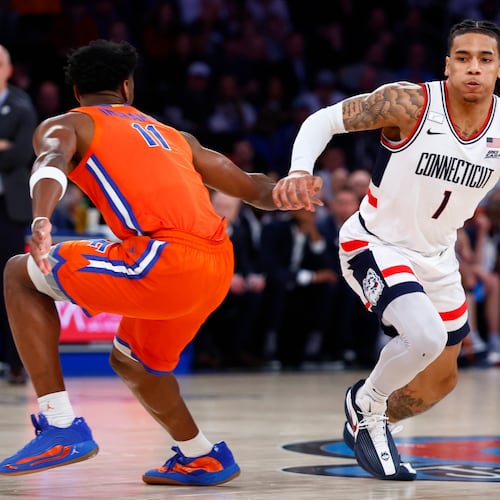 UConn guard Solo Ball (1) drives to the basket against Florida guard CJ Ingram II (11) during the first half of an NCAA basketball game, Tuesday, Dec. 9, 2025, in New York. (AP Photo/Noah K. Murray)