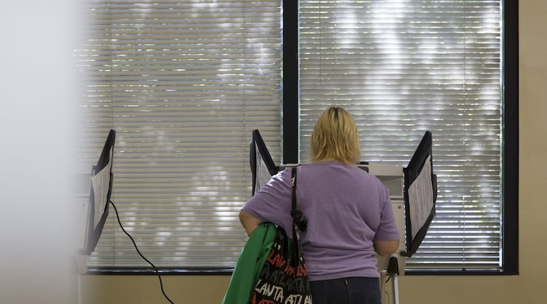 A woman votes at the Fulton County Government Center in Atlanta. Early voting is now happening in Fulton County. (CASEY SYKES / AJC FILE PHOTO)