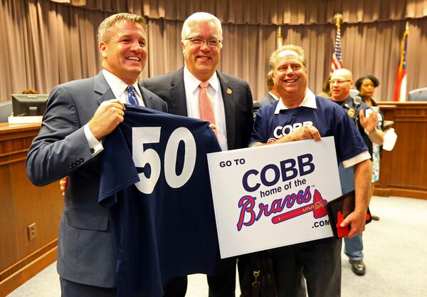Cobb County Chairman Tim Lee (center) celebrates the Braves move to Cobb