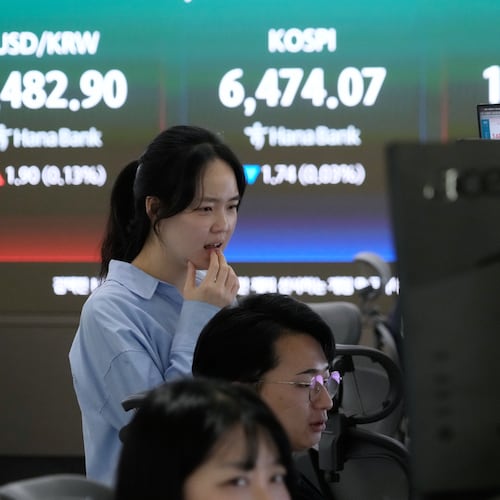 A currency trader watches monitors near a screen showing the Korea Composite Stock Price Index (KOSPI), top center, and the foreign exchange rate between U.S. dollar and South Korean won, top center left, at the foreign exchange dealing room of the Hana Bank headquarters in Seoul, South Korea, Friday, April 24, 2026. (AP Photo/Ahn Young-joon)