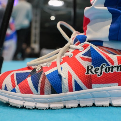 A member wears shoes in Union Flag colours during the Reform party's annual conference at the National Exhibition Centre in Birmingham, England, Friday, Sept. 4, 2026. (AP Photo/Thomas Krych)