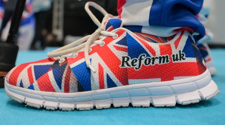 A member wears shoes in Union Flag colours during the Reform party's annual conference at the National Exhibition Centre in Birmingham, England, Friday, Sept. 4, 2026. (AP Photo/Thomas Krych)