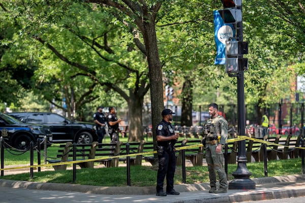 U.S. Park Police stand by as workers put up fencing around Dupont Circle ahead of the World Pride Parade, Friday, June 6, 2025, in Washington. (AP Photo/Mark Schiefelbein)