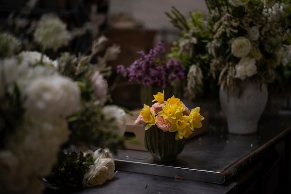 Floral arrangements by Renata Ortega, who lost her home and studio in the Eaton Fire, sit on a table in her temporary studio in Los Angeles, Friday, March 28, 2025. (AP Photo/Jae C. Hong)