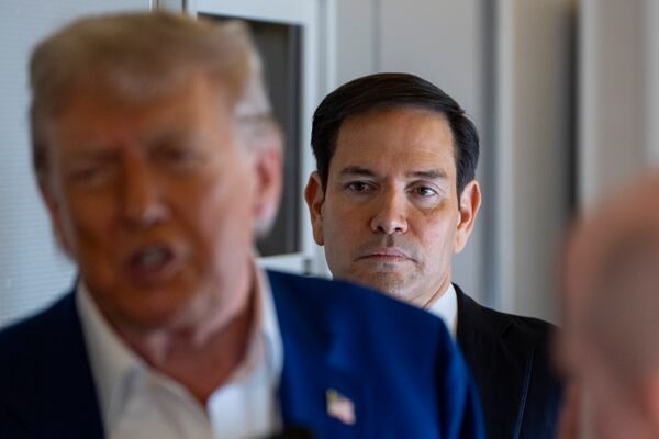 Secretary of State Marco Rubio stands behind as President Donald Trump speaks with reporters on Air Force One while in flight from Joint Base Andrews, Md., to Amsterdam, Netherlands, Tuesday, June 24, 2025. (AP Photo/Alex Brandon)