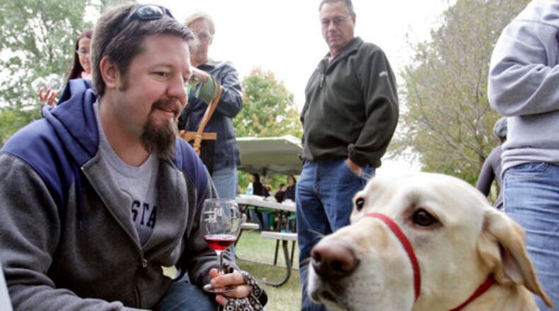 Scott Dible of Fairborn enjoys a sample of wine with his Labrador retreiver Einzig while attending the Dogtoberfest fundraiser for the Clark County Humane Society at Brandeberry Winery on Saturday, October 2, 2010.