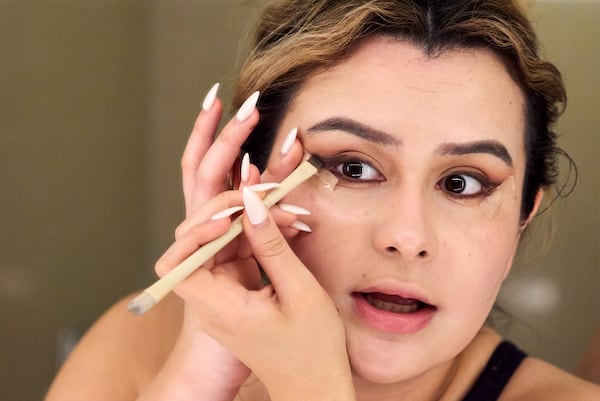 Bella Bautista, 22, a transgender woman, does her makeup in her hotel room in Arlington, Va., Wednesday, June 4, 2025, ahead of attending a dinner for strategic organizers of the National Trans Visibility March, during World Pride. (AP Photo/Jacquelyn Martin)