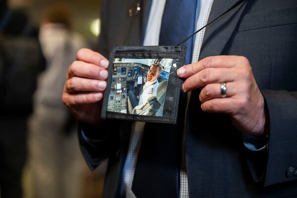 Tim Lilley wears a photo of Sam on the first day of the NTSB fact-finding hearing on the Jan. 29 mid-air collision. Sam's dream was to fly a Boeing 777 back and forth to Asia and Europe, Tim told the AJC. (Craig Hudson for the AJC)