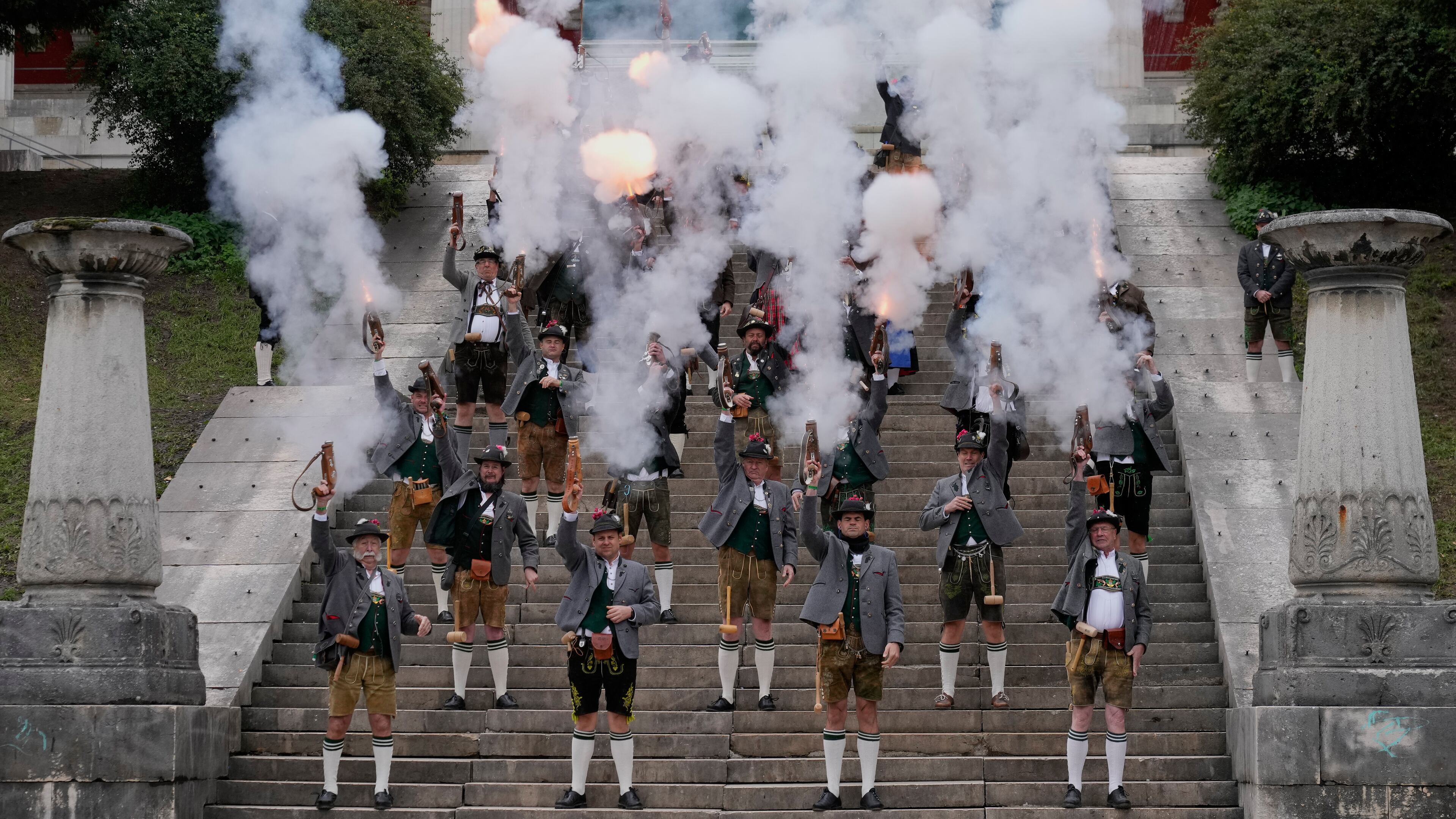 Bavarian riflemen and women in traditional costumes fire their muzzle loaders on the last day of the 190th Oktoberfest beer festival in Munich, Germany, Sunday, Oct. 5, 2025. (AP Photo/Matthias Schrader)