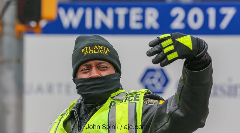Atlanta police Sgt. A. Ezell tried to stay warm Tuesday as he directed traffic at 8th and Spring streets. JOHN SPINK / JSPINK@AJC.COM
