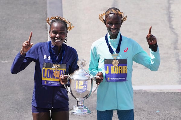 Boston Marathon winner John Korir, of Kenya, right, and women's division winner Sharon Lokedi, of Kenya, celebrate after the race, Monday, April 21, 2025, in Boston. (AP Photo/Charles Krupa)