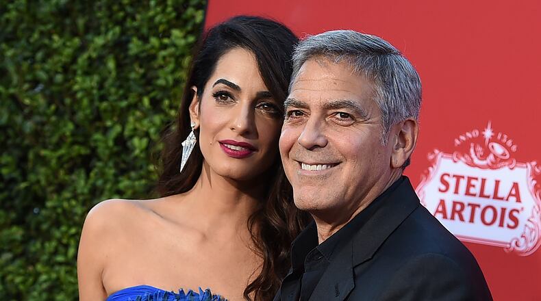 FILE - In this Oct. 22, 2017 file photo, Amal Clooney and George Clooney arrive at the premiere of "Suburbicon" in Los Angeles. George and Amal Clooney are donating $500,000 to students organizing nationwide marches against gun violence, and they say theyll also attend next months planned protests. In a statement released Tuesday, Feb. 20, the couple says they are inspired by the courage and eloquence of the survivors-turned-activists from Stoneman Douglas High School in Parkland, Fla. (Photo by Jordan Strauss/Invision/AP, File)