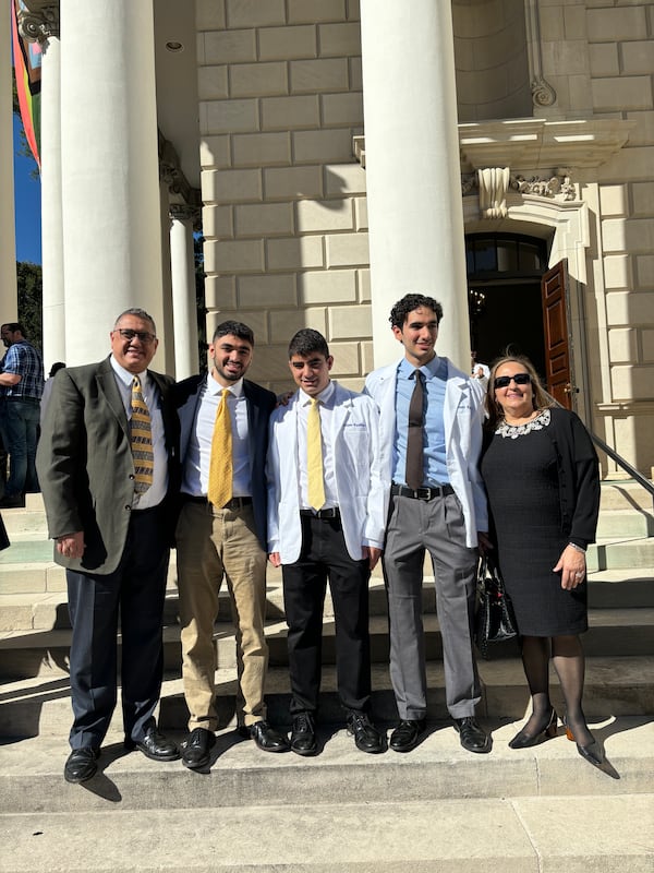 Adam and Rommi Kashlan are wearing their white coats after after the Emory University School of Medicine ceremony. Their brother, Zane, is studying at the University of Michigan Medical School. The triplets were valedictorians at West Forsyth High School in 2019 and graduated together from Georgia Tech in 2022. Courtesy photo.