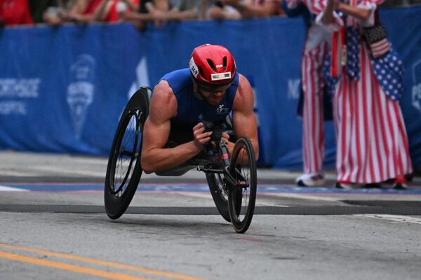 Wheelchair male division winner Daniel Romanchuk crosses the finish line of the Peachtree Road Race on Saturday. (Hyosub Shin/AJC)