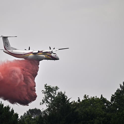 A De Havilland Canada DHC-8-400 Dash 8 operated by the French civil defense agency drops fire retardant as wildfires rage near Marcheprime, outside Bordeaux, France, Monday, July 27, 2026. (AP Photo/Emma Da Silva)