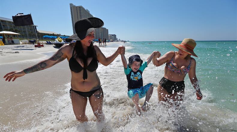 Officials have announced the temporary closure of beaches at Panama City Beach, which has long been a draw for metro Atlantans. Rachel Dunlap (from left), her son Colden, 4, and friend Heather Walker visited last year. Curtis Compton/ccompton@ajc.com