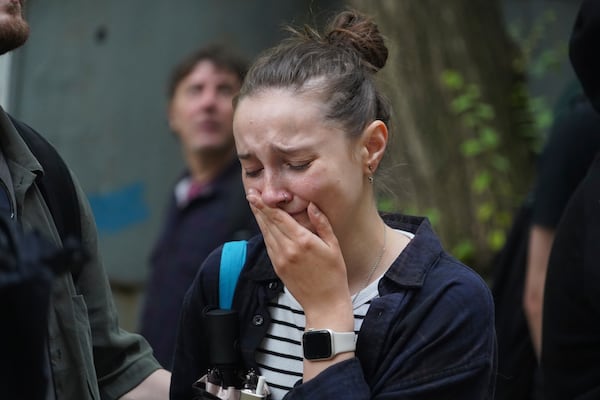 A woman reacts as she looks on a multi-storey building damaged by a Russian strike in Kharkiv, Ukraine, Saturday, June 7, 2025. (AP Photo/Andrii Marienko)